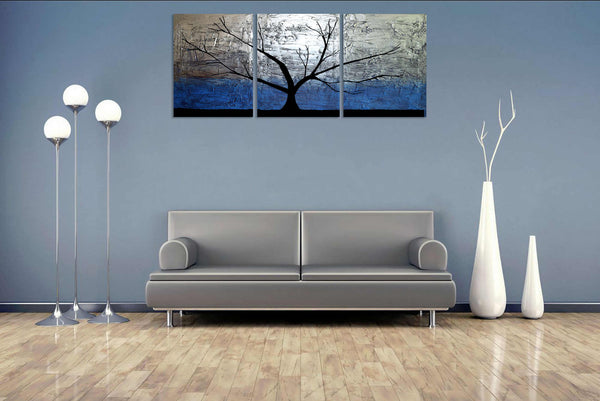 silver paintings of tree on blue wall